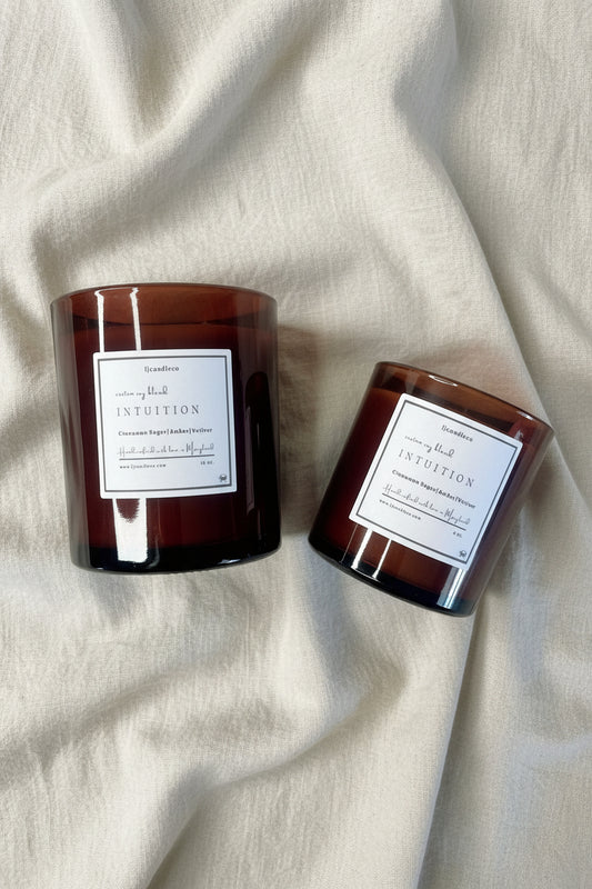 LJ Candle Co Intuition scented candle in a glass jar with a natural wood lid, featuring a calming, earthy design.