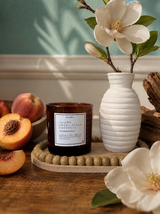 LJ Candle Co Sweet Peach Magnolia scented candle with a peach and magnolia floral design in a glass jar.